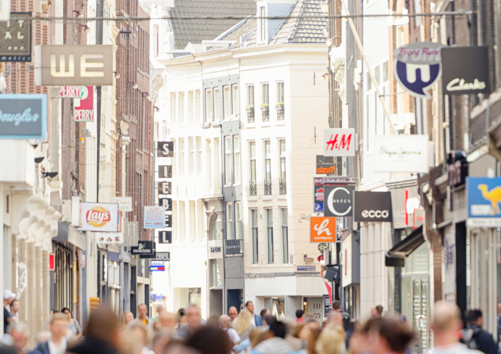 Winkelstraat in Amsterdam met zicht op reclameborden op de gevels.