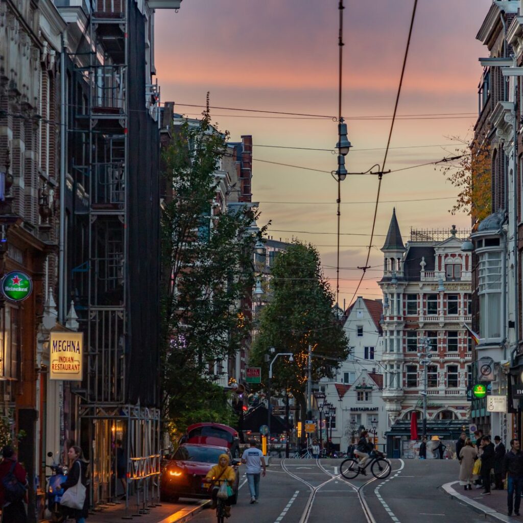 Foto van een drukke Amsterdamse straat met trambaan in schermlicht