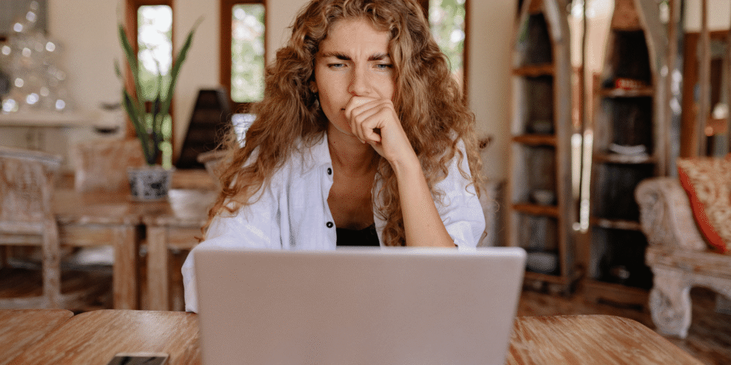 Vrouw kijkt bedenkelijk naar laptop