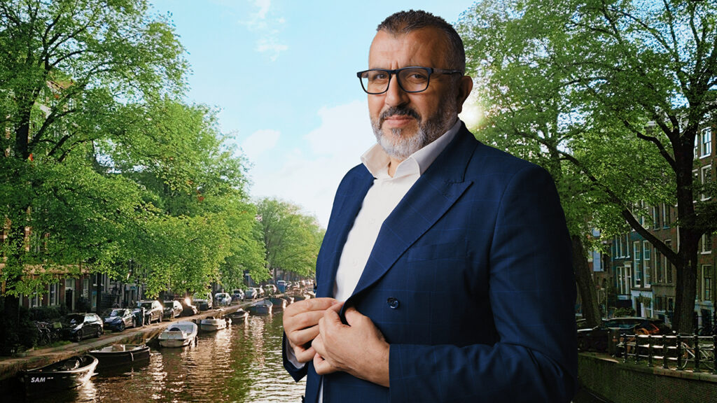 Foto van Achmed Baadoud, MKB Metropool Amsterdam, aan een gracht in Amsterdam